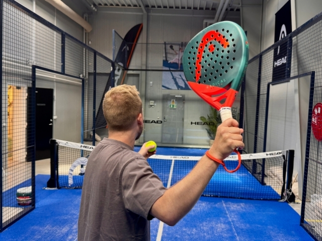 Mand holder en grøn og rød HEAD Radical padelbat op med en padelbold – test til let øvede spillere